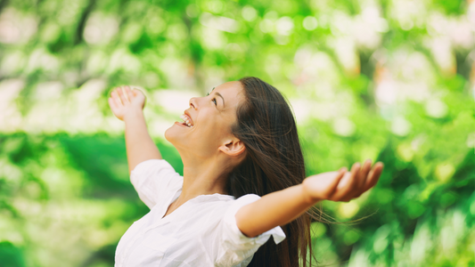 women smiling with her arms open looking up