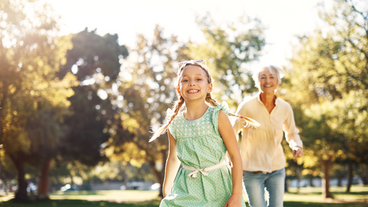 grandma smiling chasing smiling granddaughter