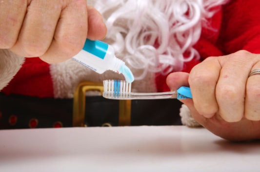 santa putting toothpaste on a toothbrush