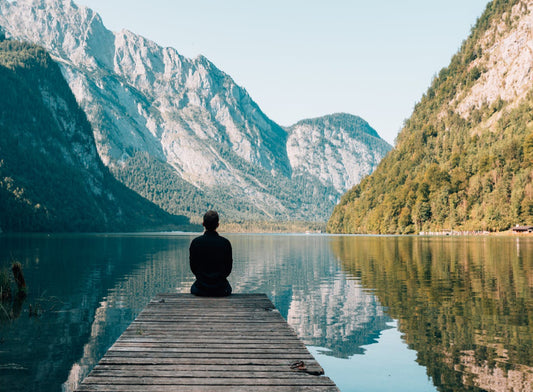 man sitting at end of dock looking out at the scenery